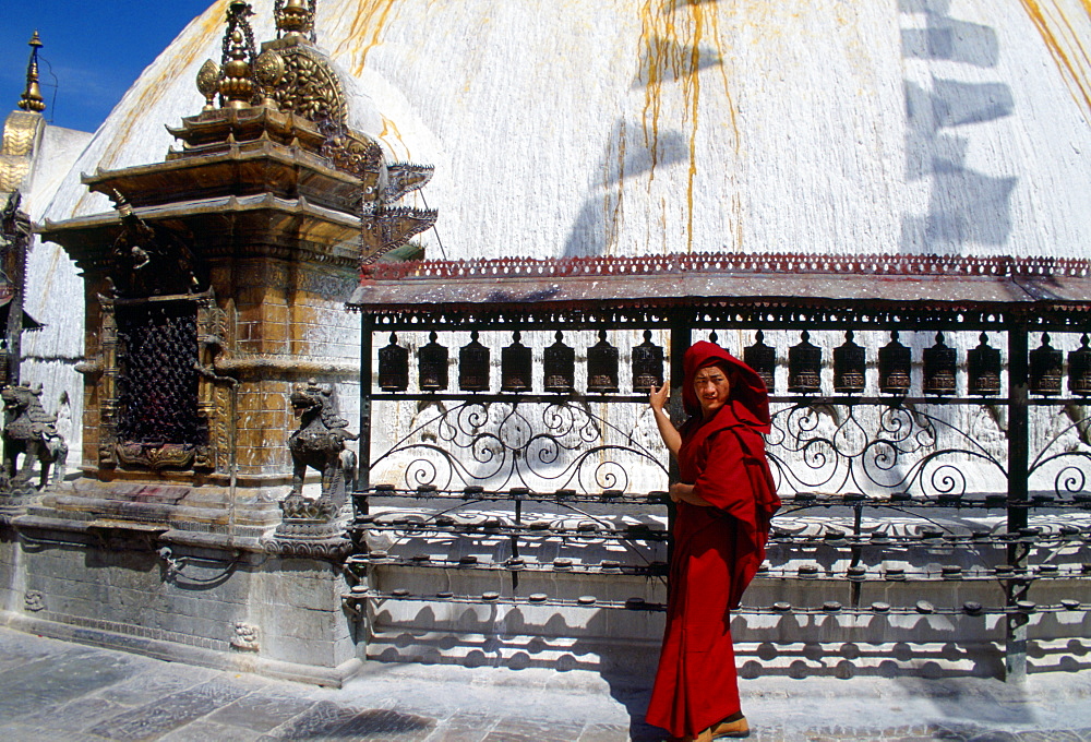 Buddhist worshipper with prayer wheels at Swayambhunath Stupa, Kathmandu Valley, Nepal.