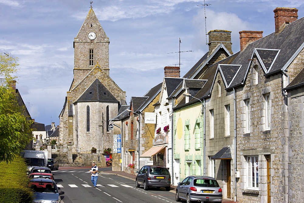 Church and street scene in French town of Trelly in Normandy, France