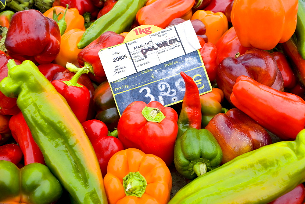 Local produce red peppers, green pepper and yellow pepper on sale at farmers market in Normandy, France