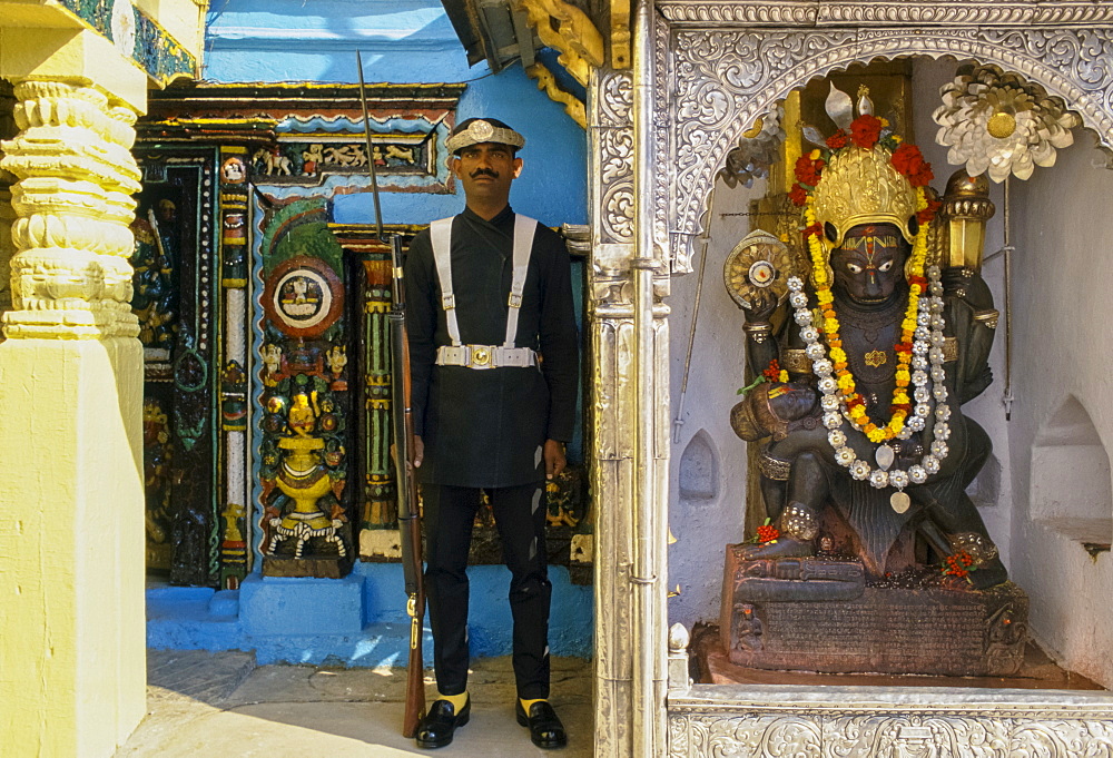 Ceremonial guard and garlanded religious statue, Kathmandu, Nepal