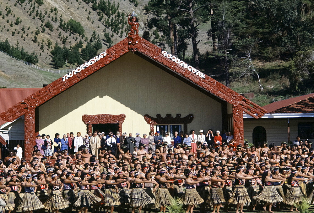 Maori women dancing at tribal gathering in front of the Wharenui meeting house at the Marae in New Zealand