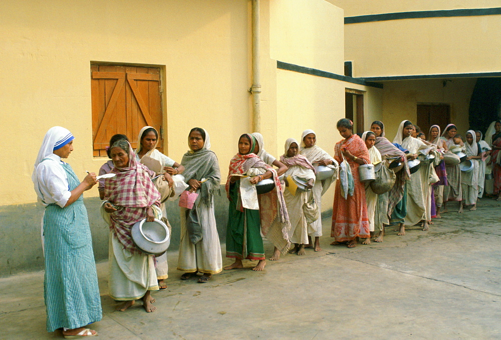 Women carrying pots in early morning food queue at Mother Teresa's Mission in Calcutta, India