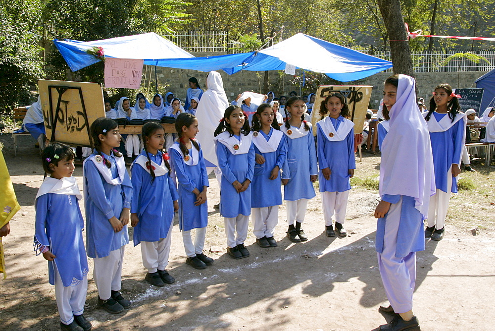 Schoolchildren have lessons outdoors after earthquake in village of Pattika, Pakistan