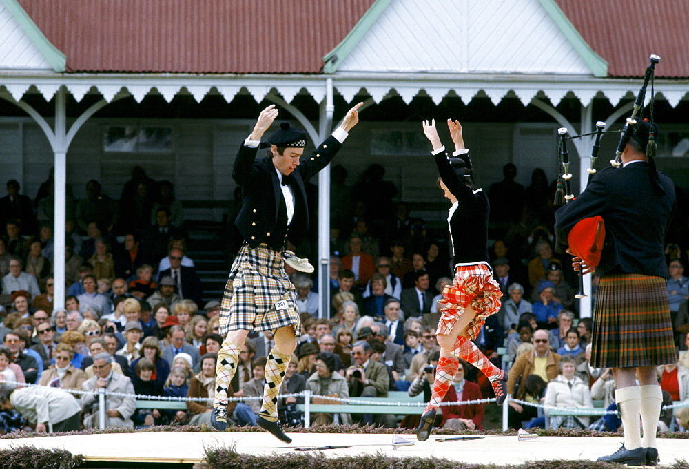 Scottish couple in tartan kilts dancing the sword dance at the Braemar Royal Highland Gathering, the Braemar Games in Scotland