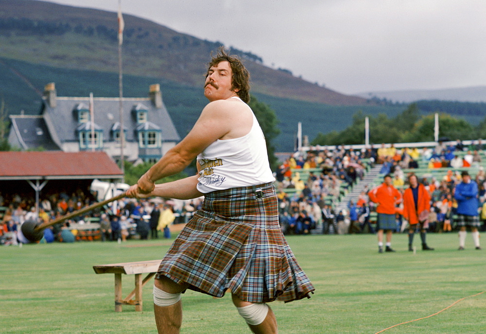 Scottish strongman in tartan kilt tossing the hammer at the Braemar Royal Highland Gathering, the Braemar Games in Scotland