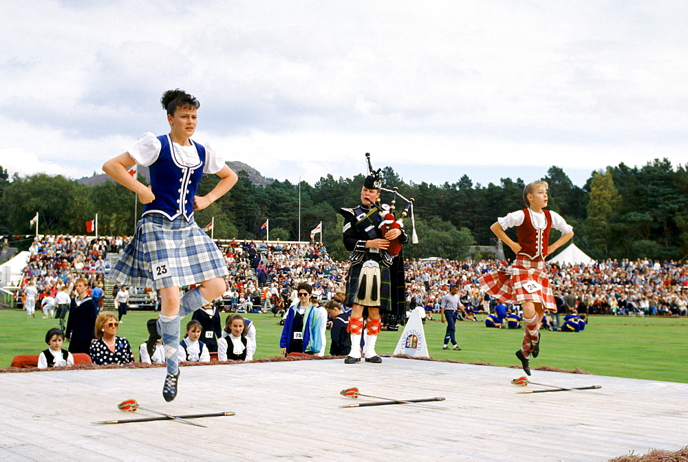 Scottish girls in tartan kilts dancing the sword dance at the Braemar Royal Highland Gathering, the Braemar Games in Scotland