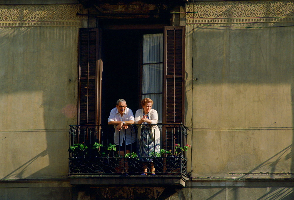 Elderly man and woman watching from the balcony of their home in Seville,Spain