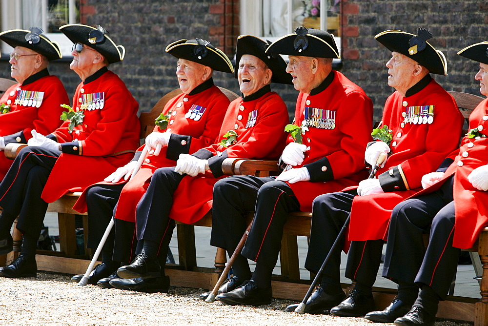 Chelsea Pensioners war veterans in traditional red and black uniforms with tricorn hats at the Royal Hospital Chelsea, London