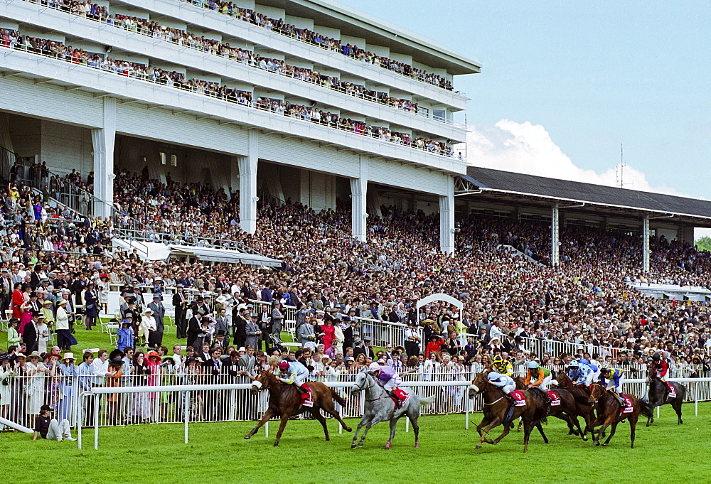 Crowds of spectactors watching the racing by the racetrack at Epsom Racecourse for Derby Day, UK