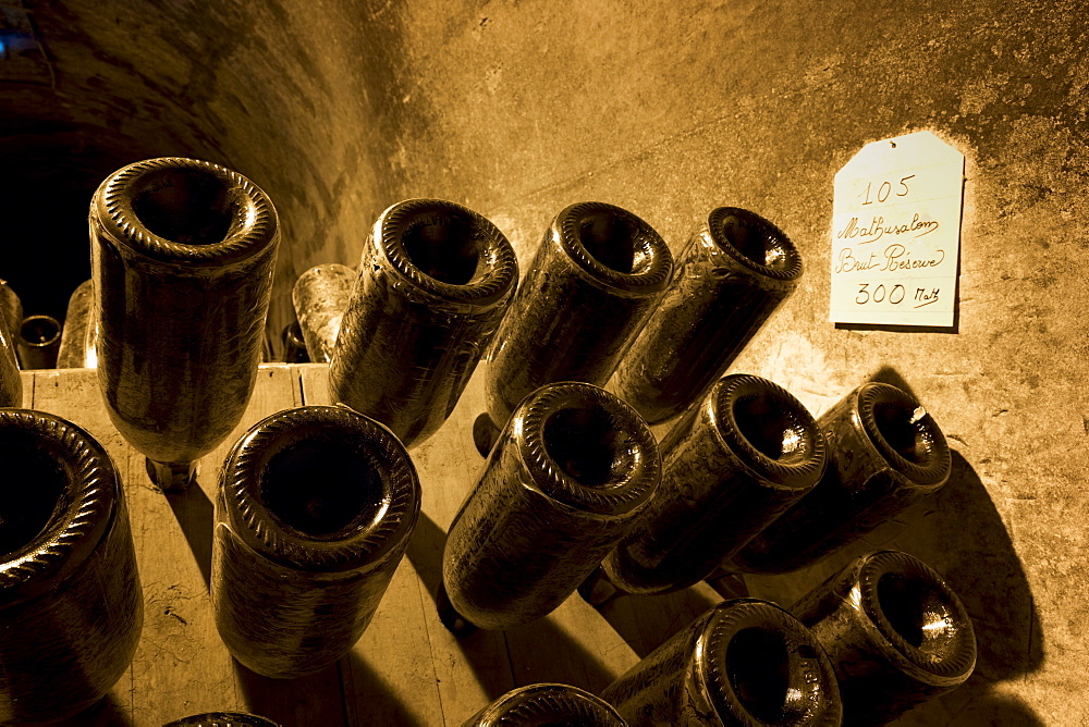 Methusalem bottles of champagne brut reserve in frames for remuage turning in caves of Champagne Taittinger in Reims, Champagne-Ardenne, France, Europe