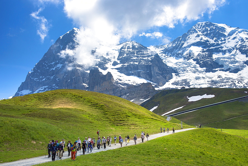 Japanese tourists on walking trail by the North Face of the Eiger mountain in the Swiss Alps, Bernese Oberland, Switzerland, Europe