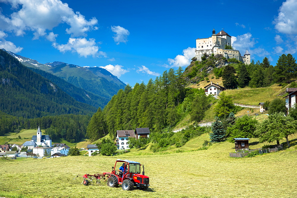 Farmer turning hay at Tarasp in the Lower Engadine Valley, Switzerland, Europe