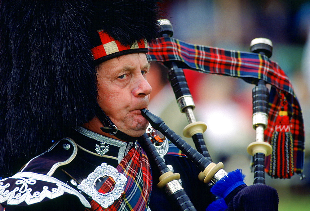 Scottish Piper playing bagpipes at the Braemar Games, Braemar, Scotland