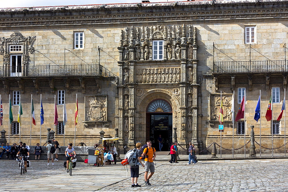 Pilgrims on Camino de Santiago pilgrim trail passing Parador Hostal de los Reyes Catolicos, UNESCO World Heritage Site, Santiago de Compostela, Galicia, Spain, Europe