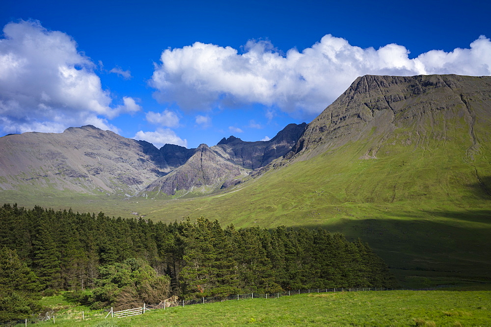 Puffy white cumulus clouds over iconic Cuillin mountain range, Isle of Skye, Inner Hebrides, Highlands and Islands, Scotland, United Kingdom, Europe