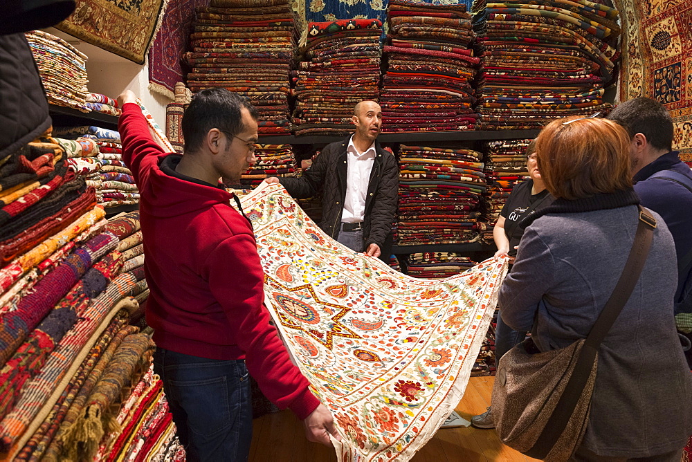 Salesman with traditional Turkish carpet in The Grand Bazaar (Great Bazaar) (Kapali Carsi), Beyazi, Istanbul, Turkey, Europe