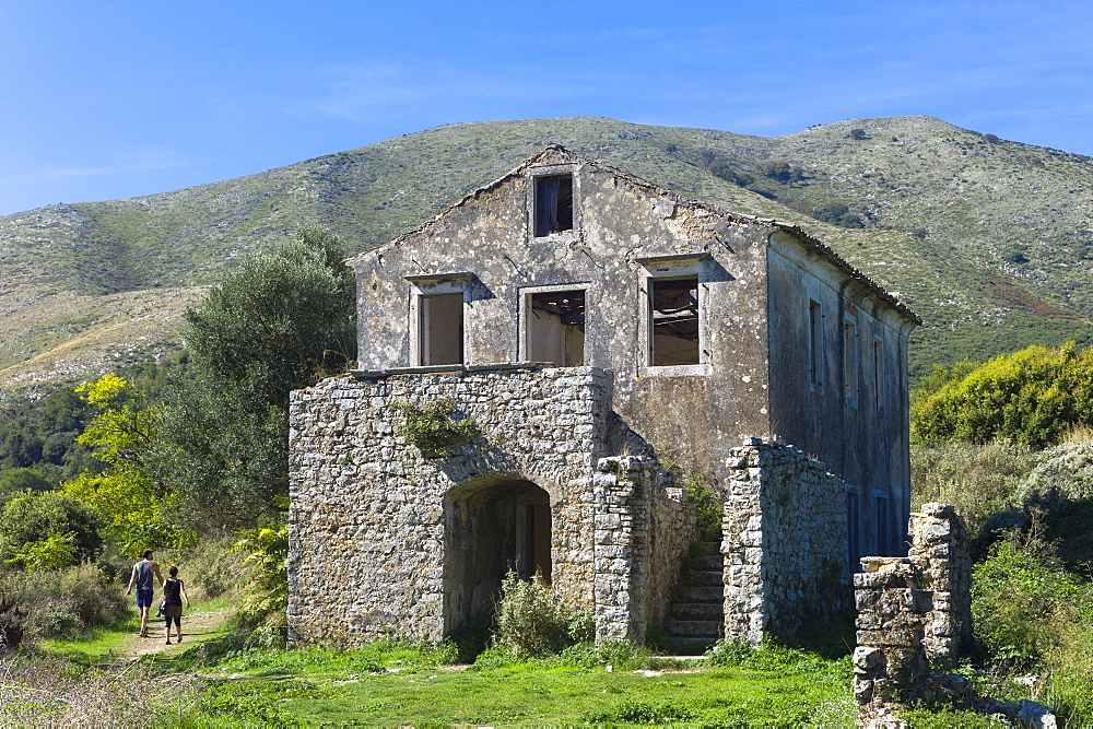 Tourists visiting Skordilis Mansion house ruin in oldest village of Corfu, ancient Old Perithia (Palea Perithea), Corfu, Greek Islands, Greece, Europe