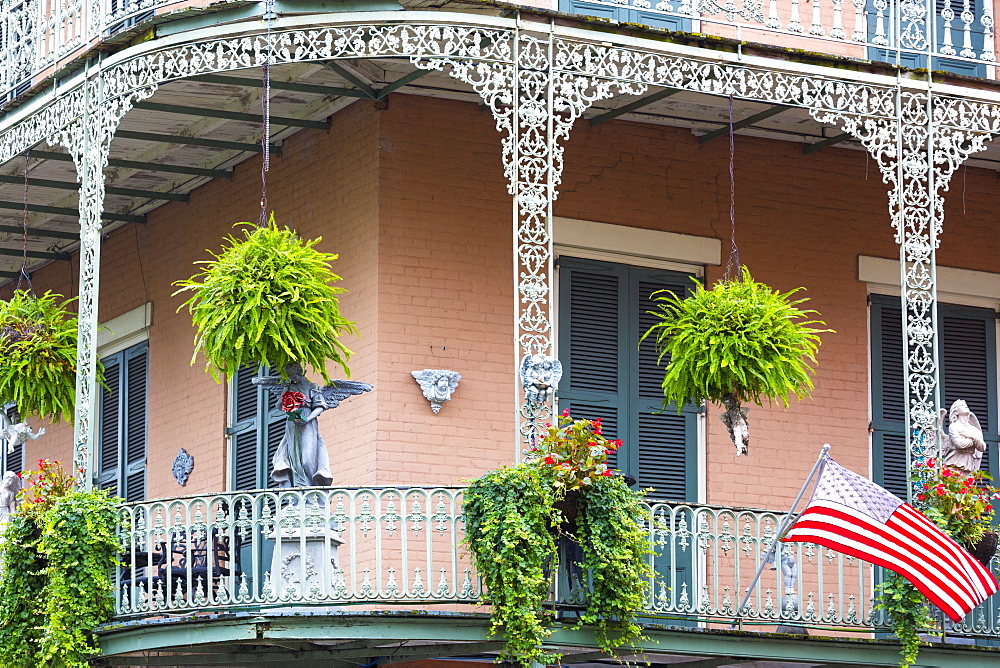 Bright architecture wrought iron balcony and flag on corner St Philip and Royal Street in French Quarter, New Orleans, USA