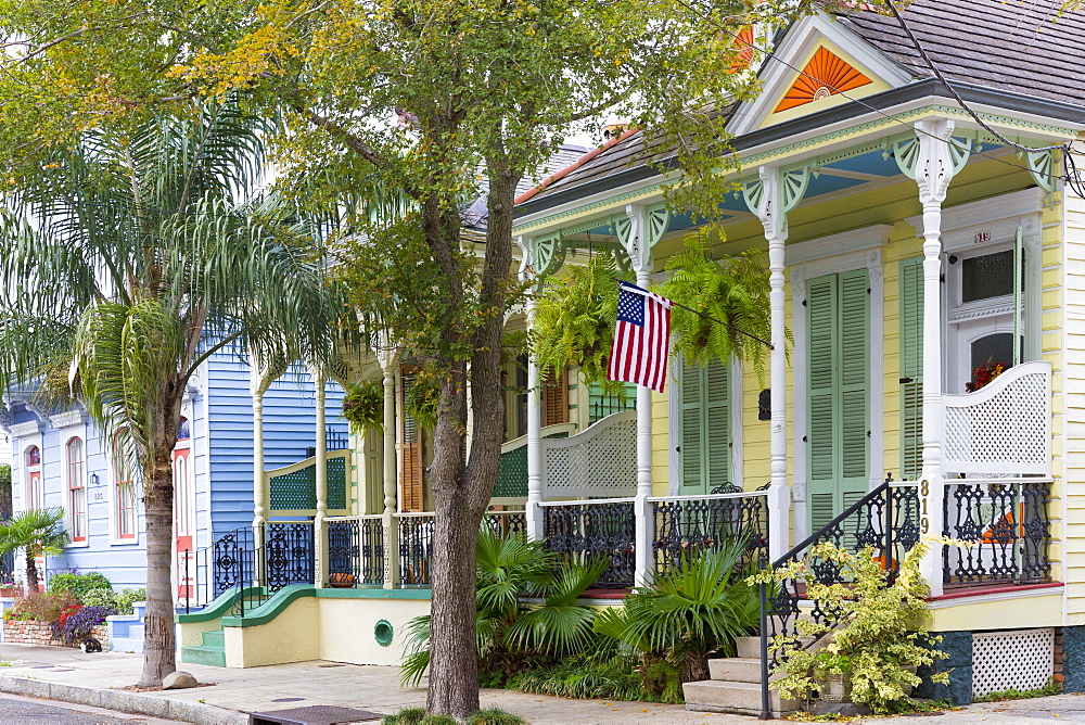 Traditional clapboard creole cottage home and stars and stripes flag in Faubourg Marigny historic district  of New Orleans, USA