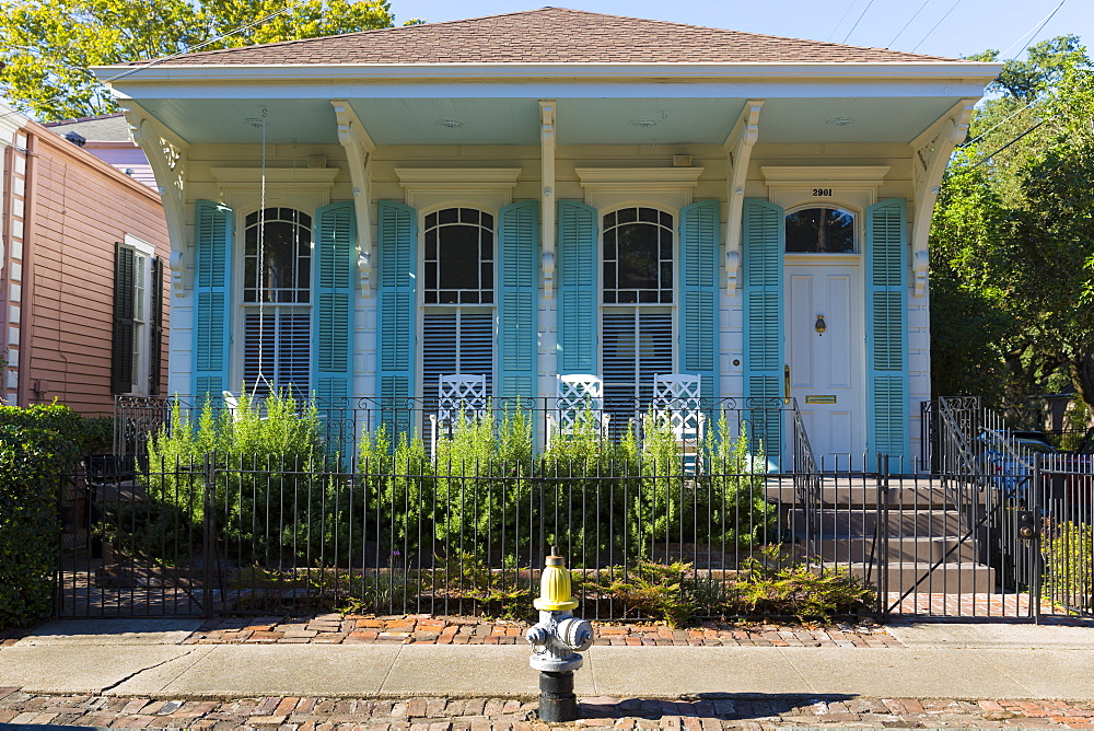 Traditional bright color clapboard cottage house in the Garden District of New Orleans, Louisiana, USA