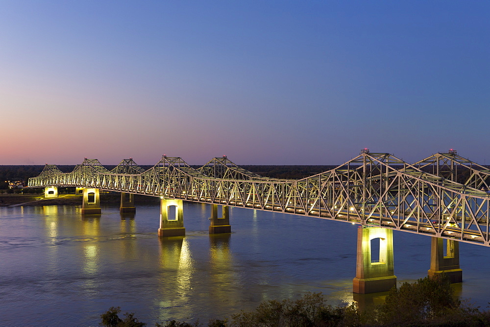 Nighttime scene of illuminated iron cantilever Natchez - Vidalia Bridge road bridge across the Mississippi River in Louisiana, USA