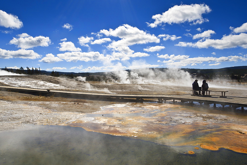 Cold tourists on seat surrounded by steam, Upper Geyser Basin, Yellowstone National Park, UNESCO World Heritage Site, Wyoming, United States of America, North America 