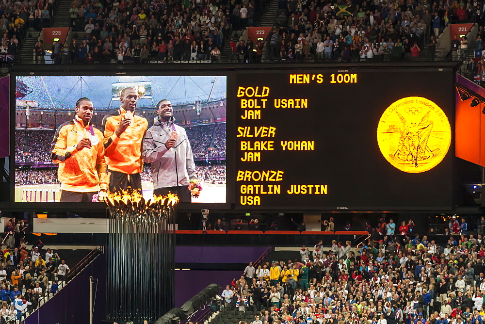 Medal ceremony Men's 100m on big screen, Olympic flame, crowds, Olympic Stadium, London 2012, Olympic Games, London, England, United Kingdom, Europe