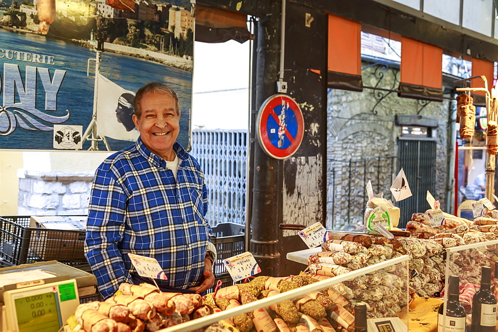 Smiling charcuterie stall holder, Marche Provencal, morning market, Vieil Antibes, French Riviera, Cote d'Azur, Provence, France, Europe