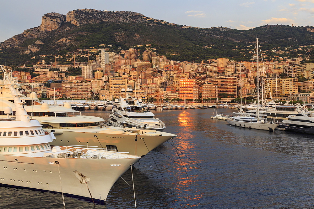 Huge super yachts in the glamorous Port of Monaco (Port Hercules) at sunrise, from the sea, Monte Carlo, Monaco, Mediterranean, Europe