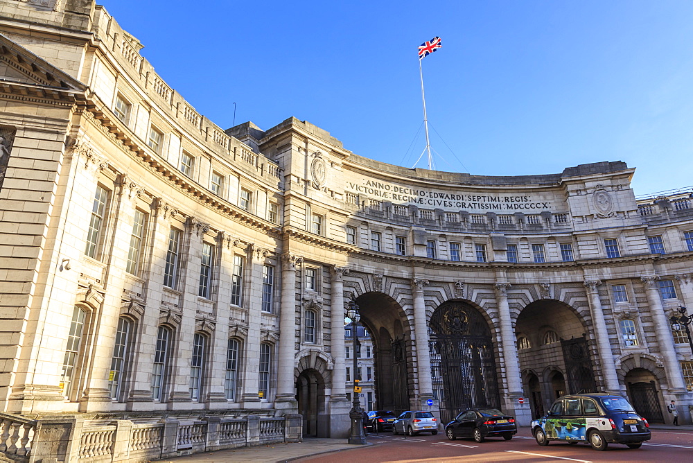 Admiralty Arch with traffic leaving The Mall and Union Flag flying, late autumn sun, London, England, United Kingdom, Europe