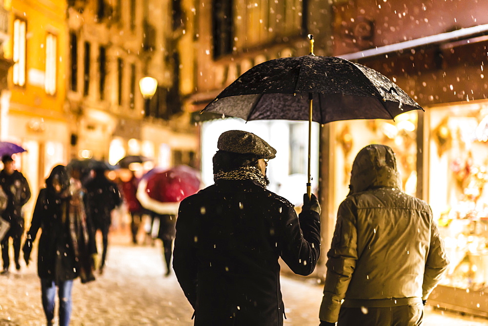 People in shopping street with umbrellas during rare snowfall, winter evening, Venice, UNESCO World Heritage Site, Veneto, Italy, Europe