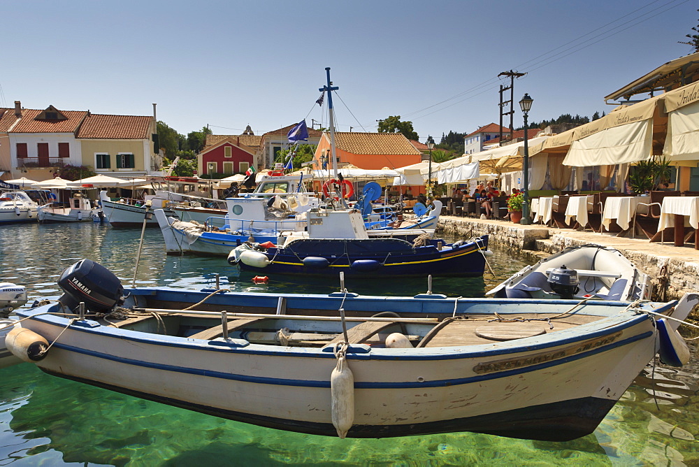 Harbourside with boats, cafes and clear green water, Fiskardo, Kefalonia (Cephalonia), Ionian Islands, Greece