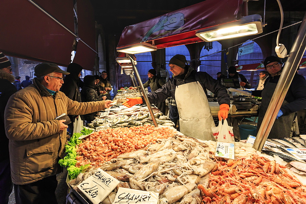 Customer pays for purchase, busy fish stall in winter, Pescheria, Rialto Market, Venice, UNESCO World Heritage Site, Veneto, Italy, Europe