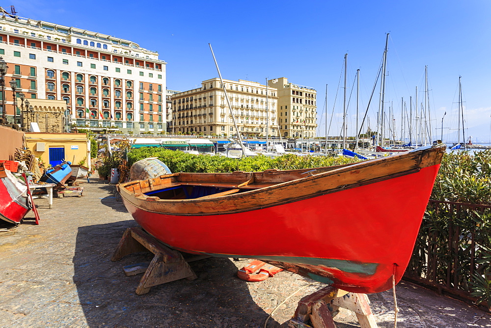 Colourful rowing boats under repair at the marina Borgo Marinaro, with backdrop of grand hotels, Chiaia, City of Naples, Campania, Italy, Europe