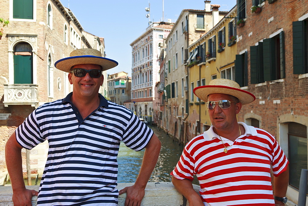 Close up of gondoliers on canal bridge with red and blue stripey tops, Venice, Veneto, Italy, Europe