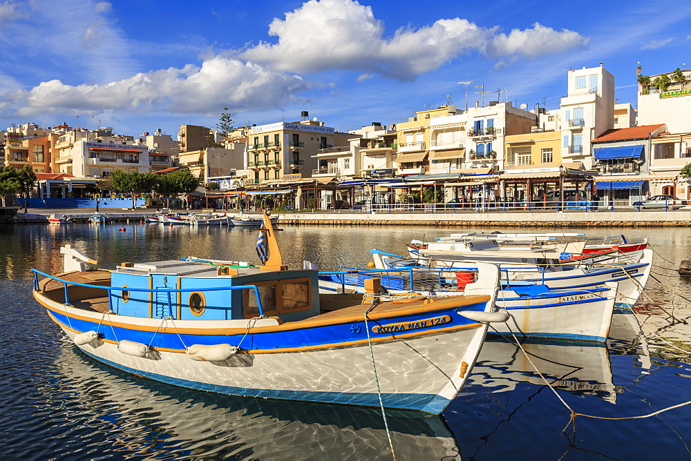 Small fishing boats reflected in Voulismeni Lake, Agios Nikolaos, Lasithi, Crete, Greek Islands, Greece, Europe