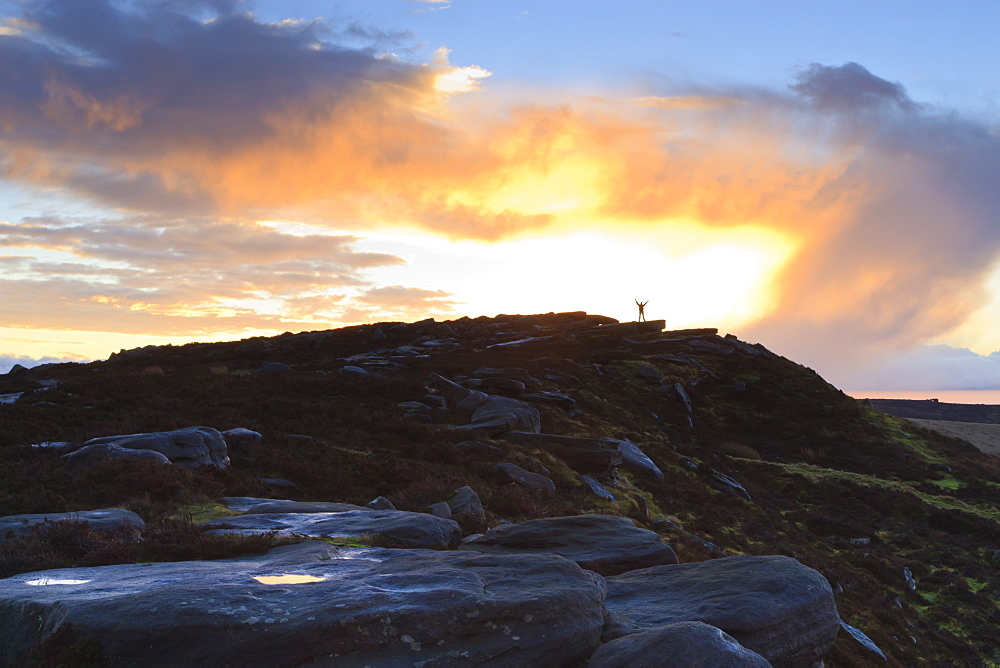 Person on rocks of Stanage Edge with winter sunrise, near Hathersage, Peak District National Park, Derbyshire, England, United Kingdom, Europe 