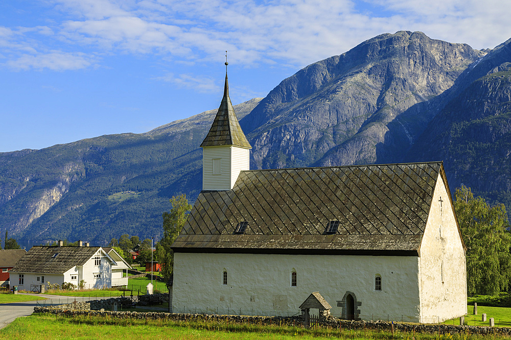 Old white church dating from 1309, sunny day, mountain and village backdrop, Eidfjord, Norwegian Western Fjords, Norway, Scandinavia, Europe