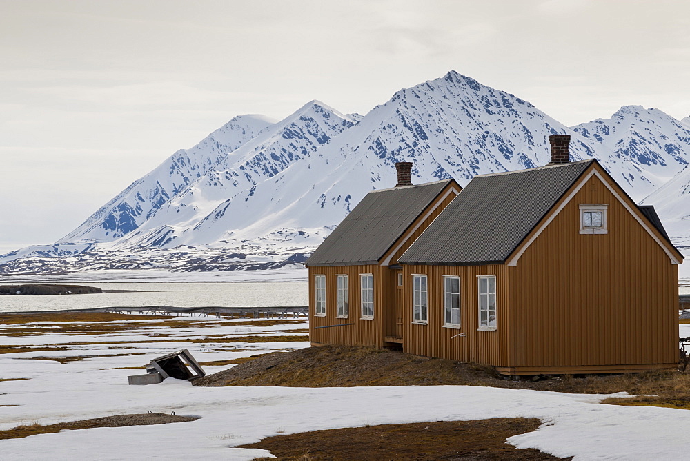 Wooden buildings with snowy mountains behind, Ny Alesund, Spitsbergen (Svalbard), Arctic, Norway, Scandinavia, Europe