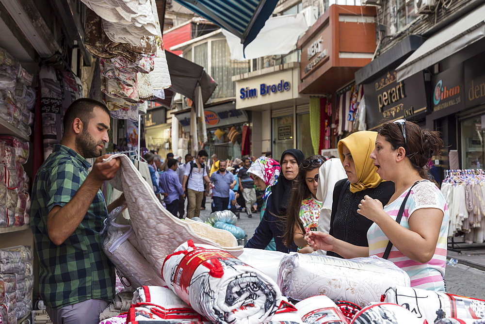 Turkish women making a bargain with a vendor (seller), street linking Grand and Spice Bazaars, Bazaar District, Istanbul, Turkey, Europe