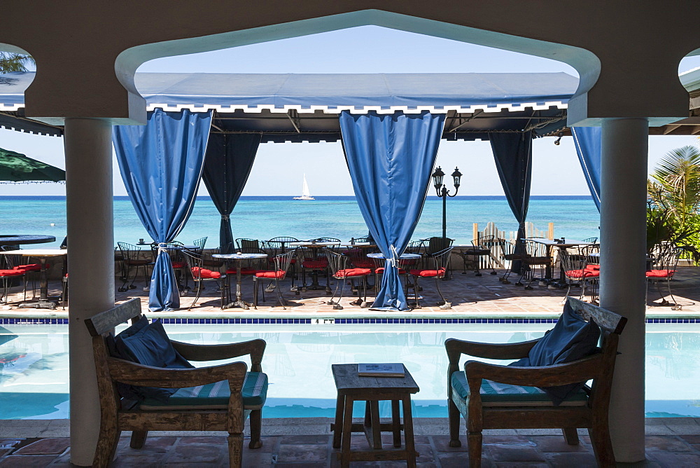 Hotel terrace with pool and view to a blue sea with passing catamaran, Cockburn Town, Grand Turk, Turks and Caicos, West Indies, Caribbean, Central America