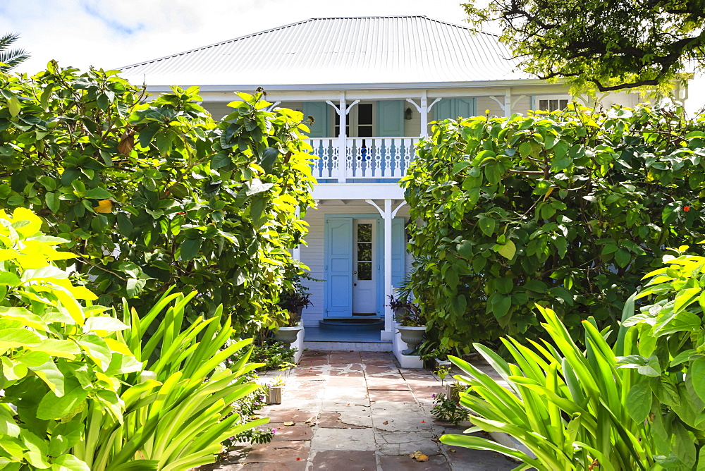 Old white wooden house with balcony, wriggly tin roof and lush garden, Cockburn Town, Grand Turk, Turks and Caicos, West Indies, Caribbean, Central America