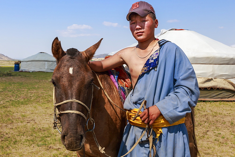 Portrait of nomad in deel with his horse, Nomad gers, Khogno Khan Uul Nature Reserve, Gurvanbulag, Bulgan, Northern Mongolia, Central Asia, Asia