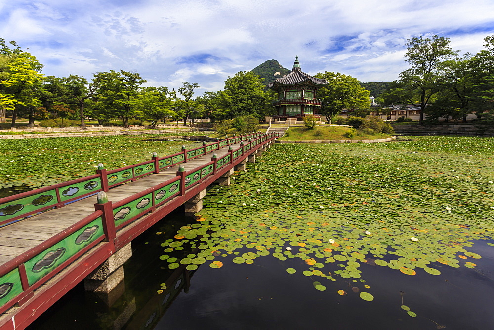 Hyangwonjeong pavilion and Chwihyanggyo bridge over water lily filled lake in summer, Gyeongbokgung Palace, Seoul, South Korea, Asia