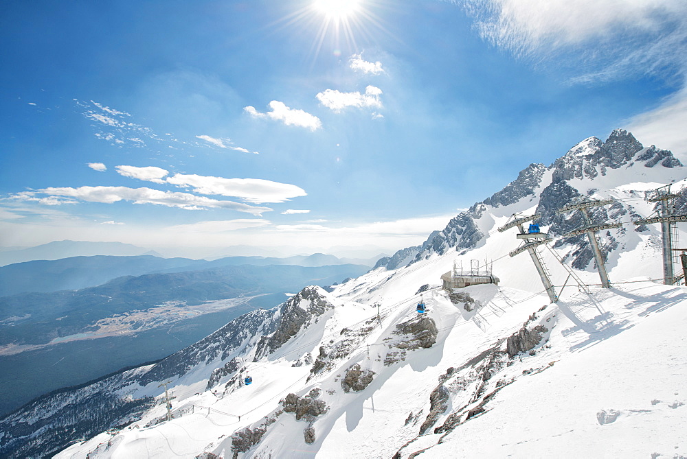 Jade Dragon Snow Mountain with blue cable cars and view on the lower regions of Yunnan, China, Asia