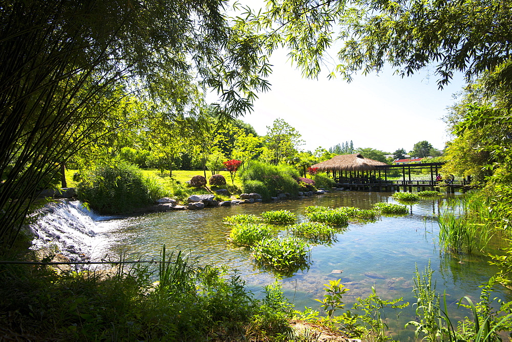 Waterfall, pond, bamboo grove and straw roof hut at West Lake, Hangzhou, Zhejiang, China, Asia