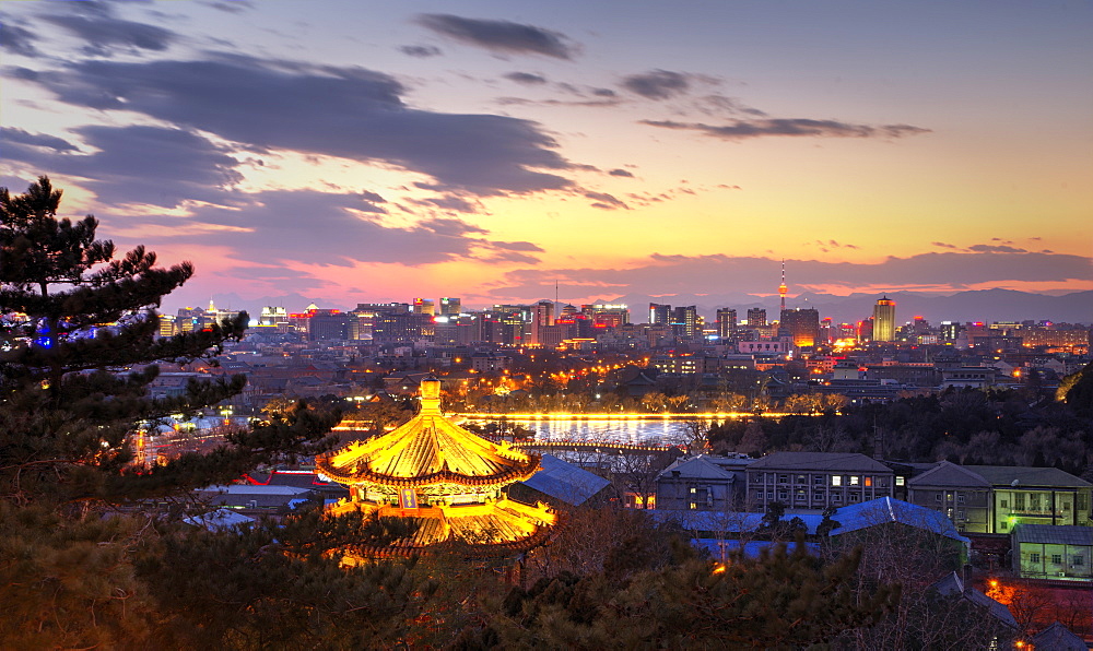 Illuminated pagoda and view towards the western part of Beijing city at nightfall, Beijing, China, Asia