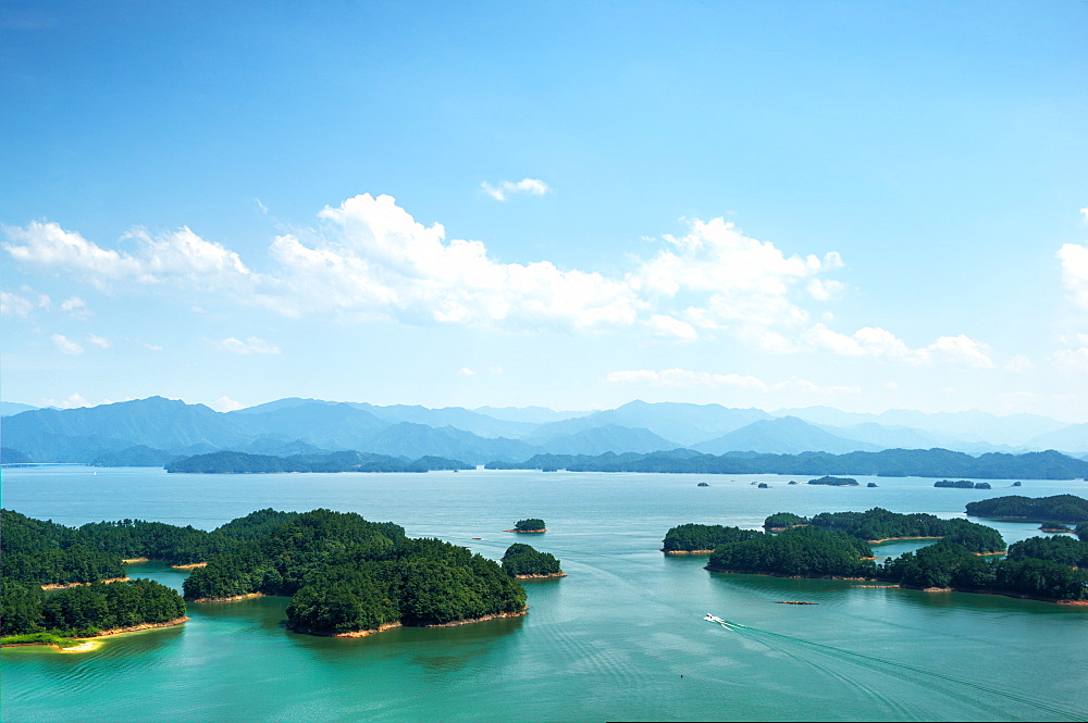 A white boat making its way across Qiandao (Thousand Islands) Lake, Chunan, Zhejiang, China, Asia