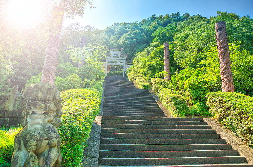 Steps flanked by stone pillars and Qi Ling lions leading up towards a stone gate, Zhejiang, China, Asia