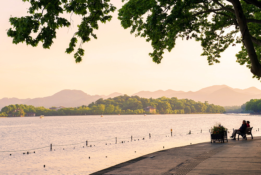 West Lake shore with hilly landscape and silhouettes, Hangzhou, Zhejiang, China, Asia 